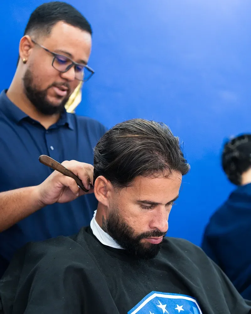 Barbeiro penteando o cabelo do cliente